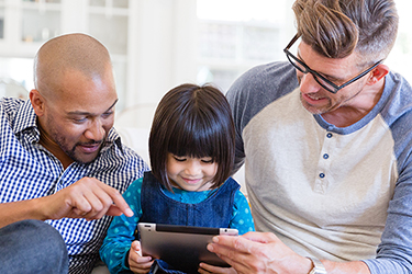 Parents with child looking at a Notepad